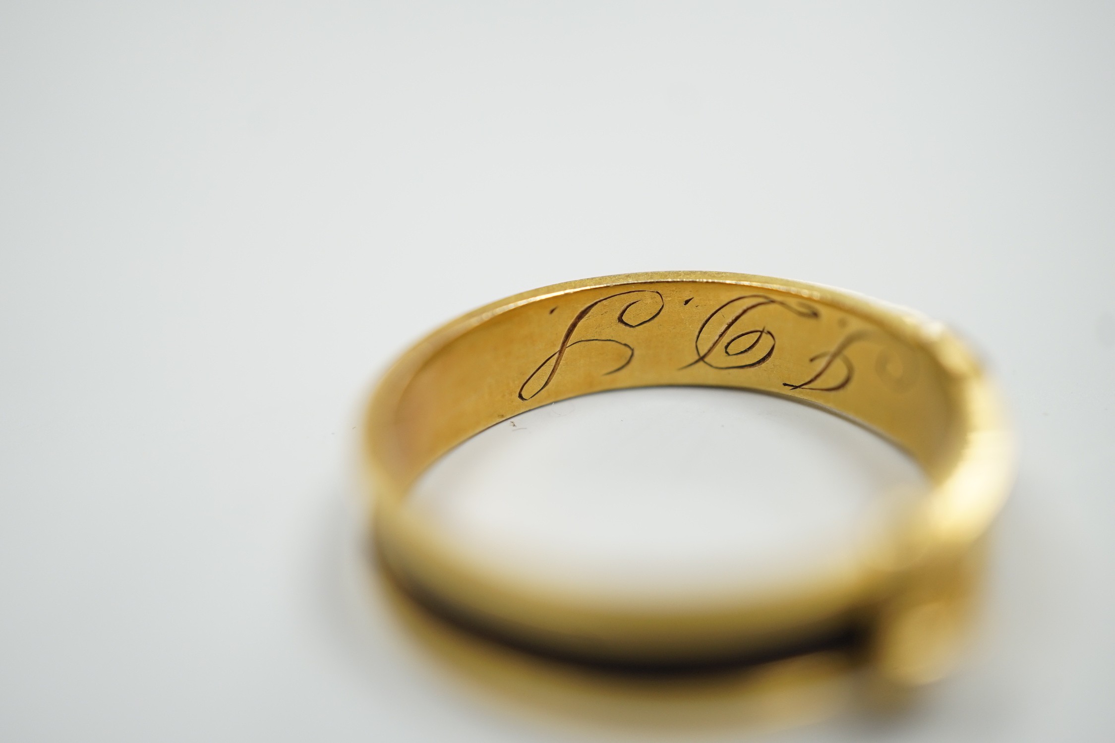 A 19th century yellow metal and plaited hair mourning band, modelled as a buckle, the shank interior engraved with the initials JDS?, size O/P, gross weight 2.1 grams.